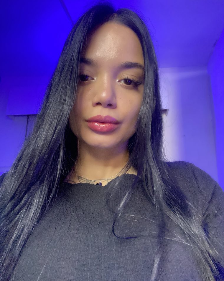 Luna in a close-up selfie under violet light